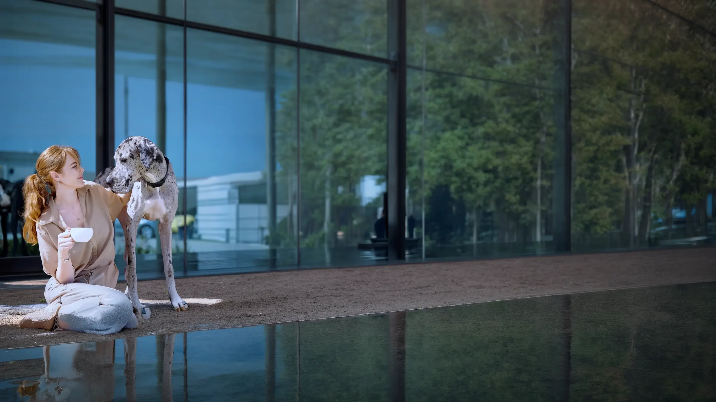 Alana Annear sitzt mit ihrem Hund, eine Tasse Kaffee in der Hand